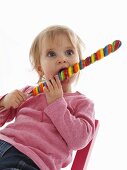 A small child eating a giant lolly