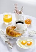 Frühstück mit Kaffee, Croissant, Spiegeleiern, Marmelade, Orangensaft