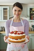 A woman with a strawberry cake