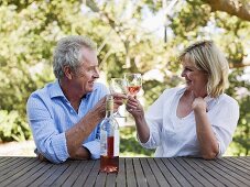 A couple toasting with wine outdoors
