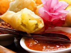 Fried pastries with potato filling and spicy sauce