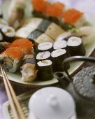 Assorted Nigiri sushi and Maki sushi; teapot