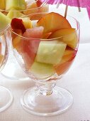 Bunter Obstsalat mit Melone in Gläsern mit Schirmchen