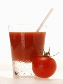 Tomato juice in glass with straw; cherry tomato