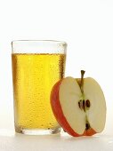 Glass of apple juice beside half an apple