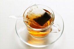 Tee in Glastasse mit Teebeutel und Löffel