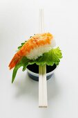 Nigiri-Sushi mit Garnele und Shisoblatt auf Sojasauce