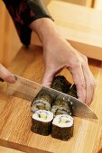 Cutting rolled sushi into pieces