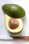 Avocado, halved, with knife