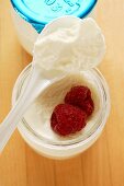 Jar of yoghurt with fresh raspberries