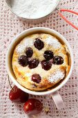 Quark and semolina pudding with cherries and icing sugar in cup