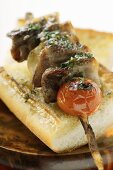 Barbecued pork kebab on sesame baguette