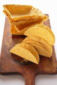 Assorted taco shells on chopping board