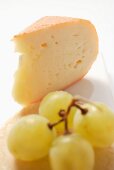 Piece of Chaumes cheese with green grapes