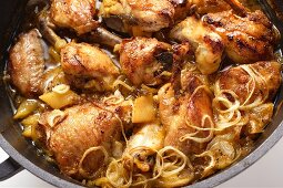 Braised chicken with onions in cast-iron frying pan