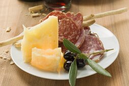 Salami, Käse, Oliven und Grissini auf Teller