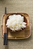 Schale Reis und Essstäbchen auf Tablett