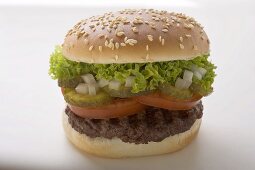 Hamburger with tomato, gherkin, onion and lettuce