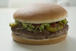 Hamburger mit Gewürzgurke, Salat und Ketchup