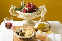Oliven, Parmesan, Brot, Olivenöl, rote Trauben und Rotwein