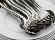 Pile of plates with spoons and forks