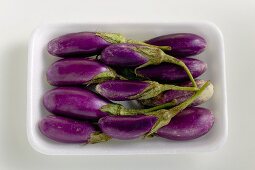 Baby aubergines in white dish