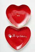 Rote herzförmige Teller mit Schrift Be my Valentine und Love
