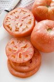 Tomaten, ganz, halbiert und Scheiben, mit Wassertropfen