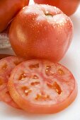 Tomatoes, whole and slices, with drops of water