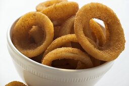 Deep-fried onion rings in white bowl