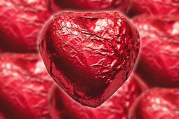 Herzförmige Pralinen in roter Folie zum Valentinstag
