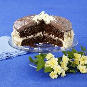 Chocolate almond cake on cake stand, a piece cut