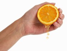 Woman's hand squeezing an orange