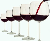 Five red wine glasses in a row