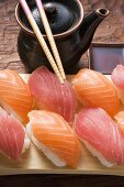 Nigiri sushi, chopsticks and pot