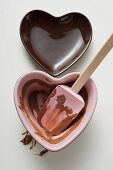 Two heart-shaped bowls, one with remains of chocolate sauce