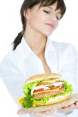 Young woman holding a giant hamburger on a board