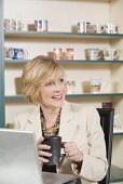 Mature woman at laptop with a cup of coffee