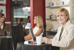 Frau mittleren Alters am Laptop in einem Café