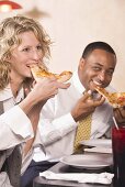 Man and woman eating pizza