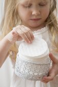 Girl holding crocheted container of cosmetic pads