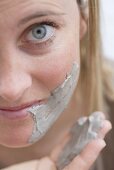 Young woman applying a face mask