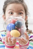 Girl with coloured Easter eggs in a jar