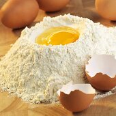 Baking ingredients: egg in well in mound of flour
