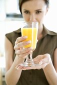 Young woman holding a glass of orange juice