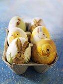 Easter eggs painted with animal motifs in an egg box