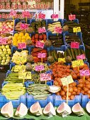 Gemüse und Obst mit Preisschildern in Kisten