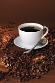 Eine Tasse schwarzer Kaffee und Kaffeebohnen