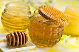 Jars of honey and honey dipper