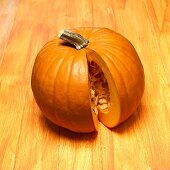 An orange pumpkin with a piece removed